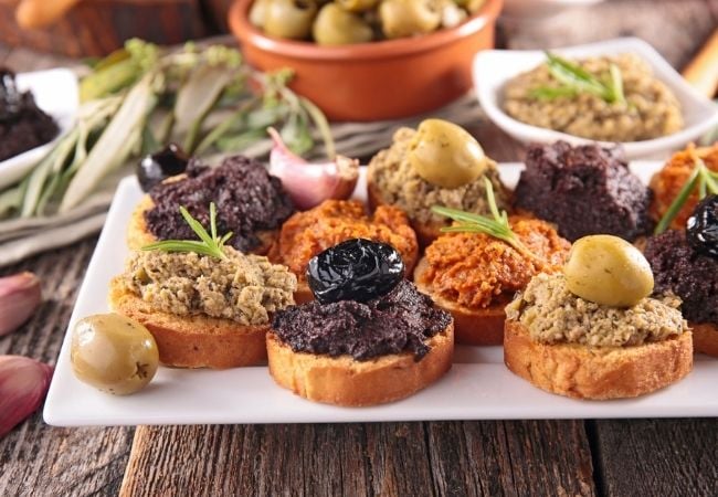 Crostini with black olive tapenade, green olive tapenade, and sun-dried tomato tapenade
