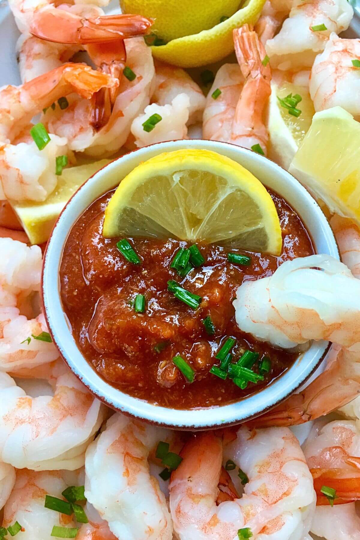 Homemade Cocktail Sauce Served with Shrimp and Lemons 