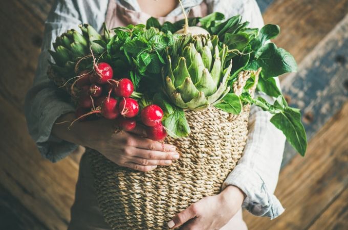 Basket with vegetables including radishes and artichokes