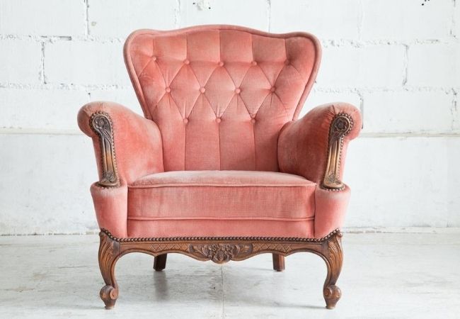 Comfortable velvet chair against a white wall