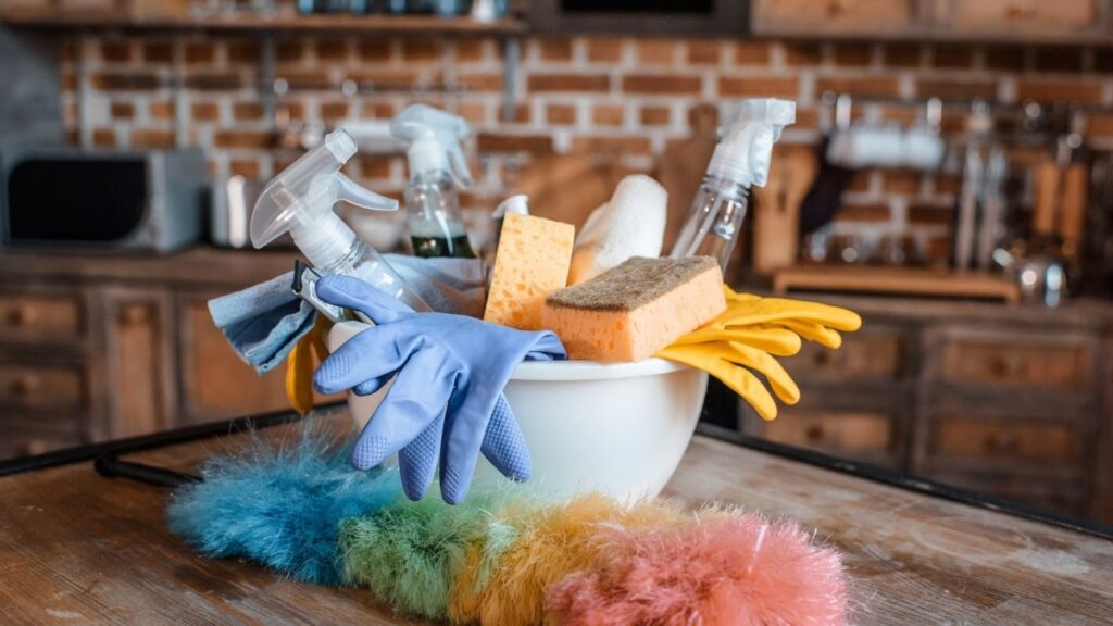How to Add Hygge to Your Cleaning - Cleaning supplies in a bowl with a Duster in a Rustic Kitchen
