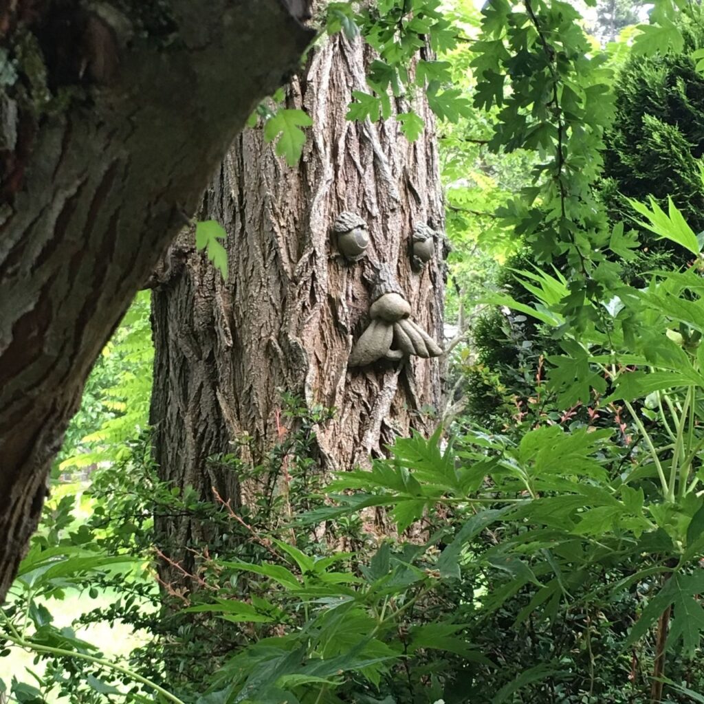 Tree trunk with eyes, nose, and mouth in the garden. Best Ideas for Garden Decor