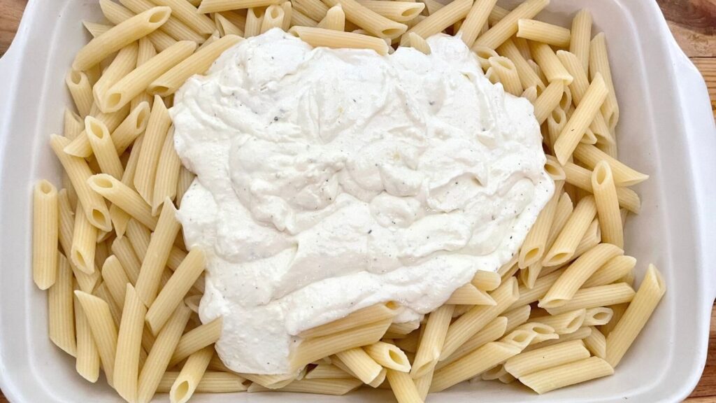 Cooked penne pasta with sour cream, butter, lemon mixture on top.