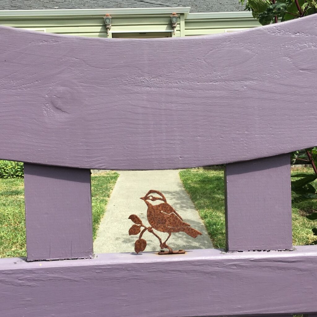 Fun Ideas for Garden Decor - Little rusty metal bird in the center of a wooden garden gate
