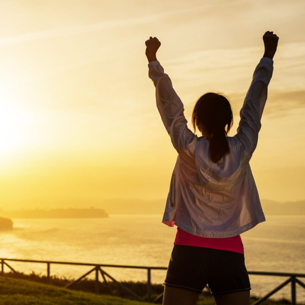 31 Small Goals Easily Achieved in 2021 - Woman at sunrise with her fists up in the air