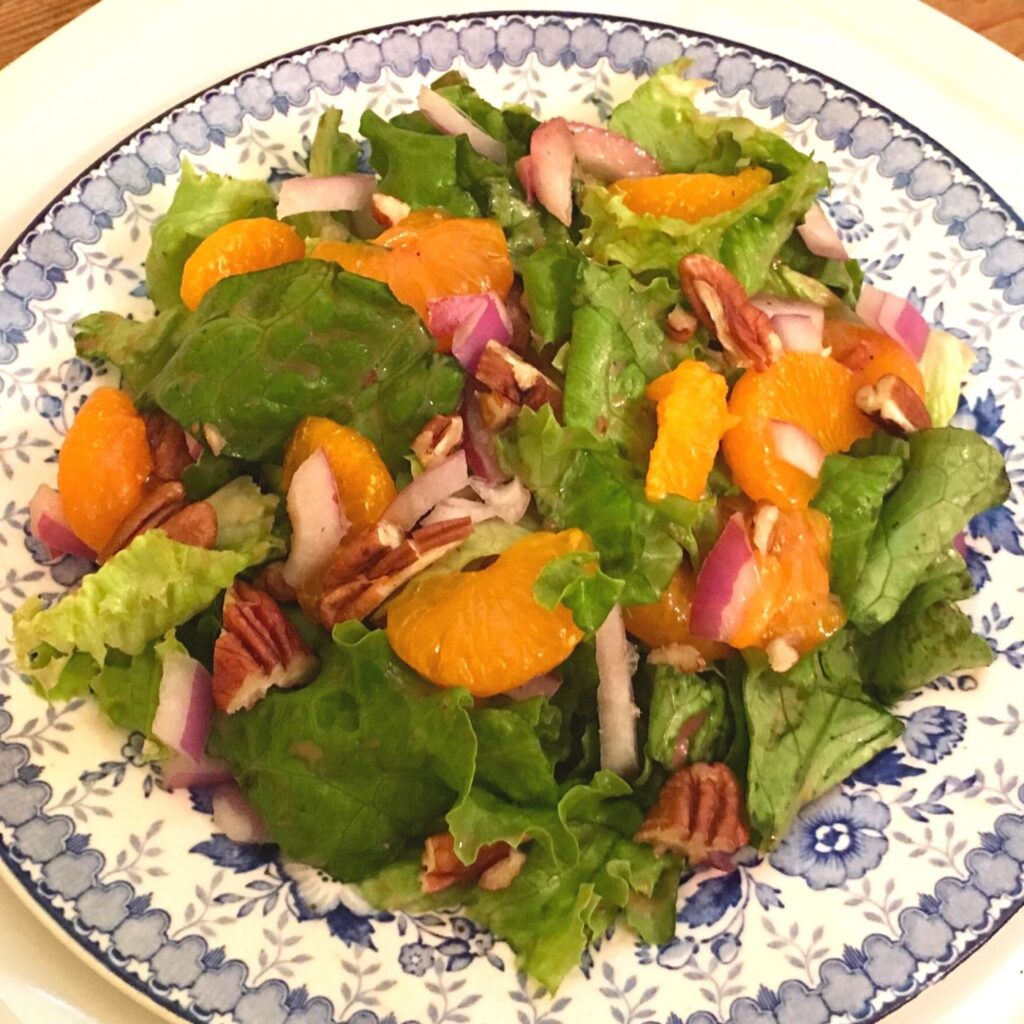 Mandarin Orange Salad with Raspberry Vinaigrette on a blue and white plate