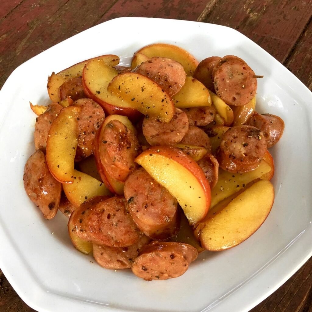 Skillet Chicken Sausages and Apples in a White bowl on a rustic surface