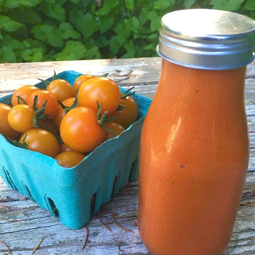 The Best Honey French Salad Dressing Recipe in a bottle and a pint of cherry tomatoes