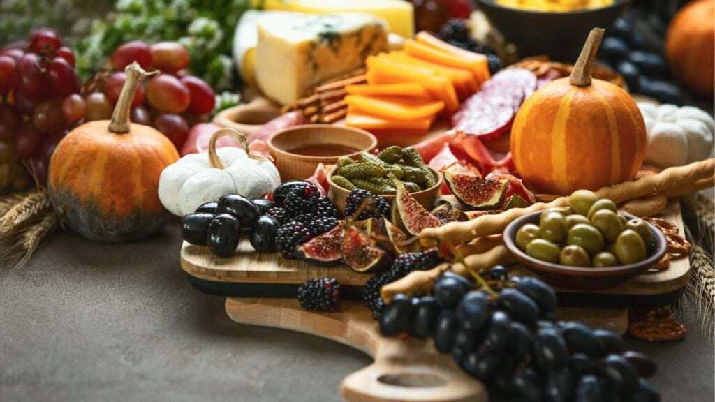 Fall Charcuterie Board with Artisan cheese, crackers, mini pumpkins, seasonal fruit, honey, and meats