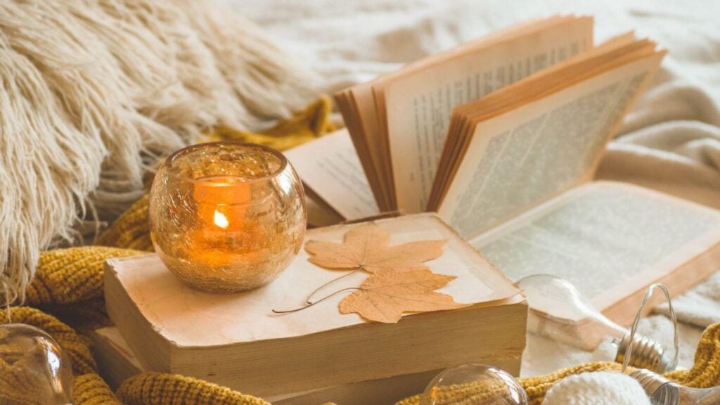 Fall Aesthetic Photos - Photo of a Candle on Top of a Book and Fall Leaves