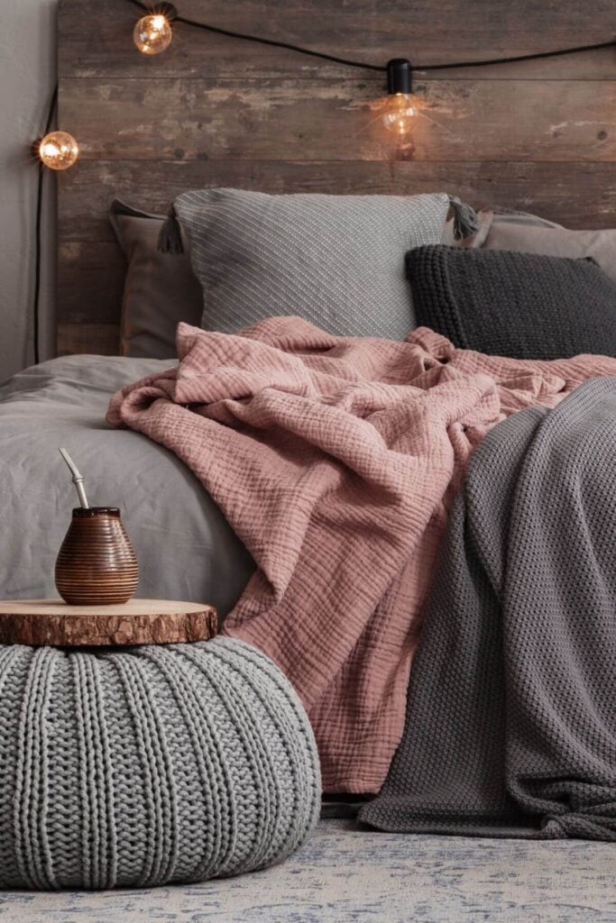 How to Create a Cozy Bedroom - Photo of a Rustic Gray and Pink Bedroom -Create the ultimate cozy rustic bedroom with the perfect blend of soft gray and blush pink linens. This warm and inviting bedroom style pairs neutral tones with romantic accents for a peaceful, country-inspired retreat. Think reclaimed wood furniture, chunky knit throws, and vintage lighting to complement the soothing gray and pink color palette. Whether you're updating your farmhouse decor or creating a rustic cottage bedroom, this look brings charm, comfort, and timeless style. Pin this cozy rustic bedroom idea for your next home decor project!