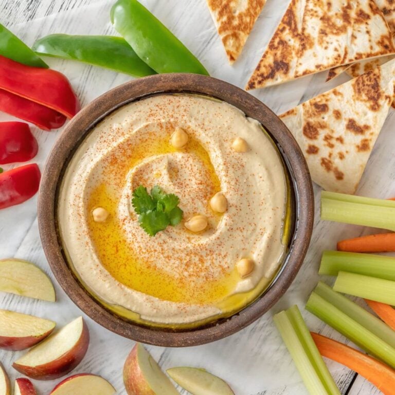What to Eat with Hummus? Photo of a Bowl of Hummus with Pita, Apples, Celery, and Peppers