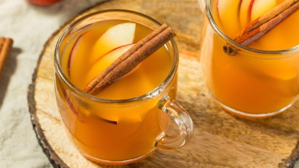 The Best Spiced Apple Cider Recipe - Photo of Spiced Apple Cider with Cinnamon Sticks and Sliced apples